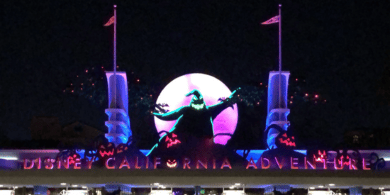 Entrada do Disney California Adventure à noite durante o Halloween no Disneyland Resort com decorações Oogie Boogie anunciando o Oogie Boogie Bash