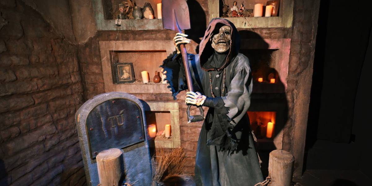Um monstro esquelético chamado El Muerte próximo a uma lápide com Tú (Você) escrito nela Universal Studios