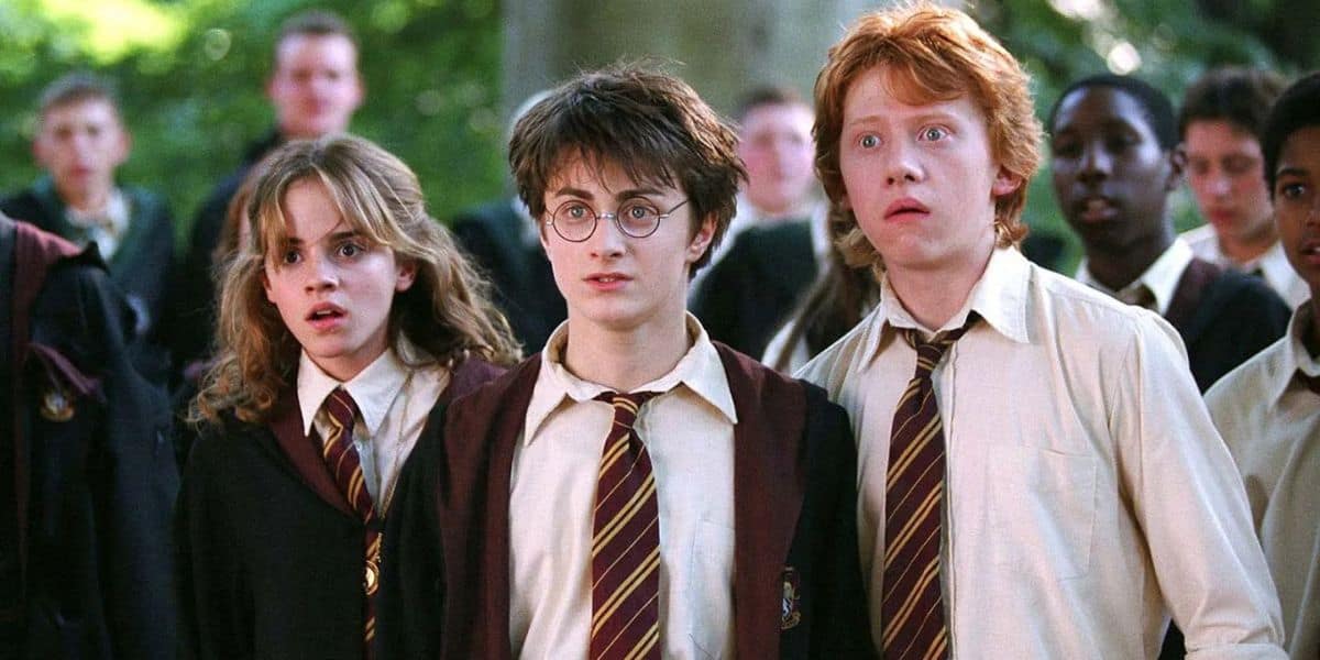 Hermione, Harry e Ron olhando em estado de choque com seus colegas de classe