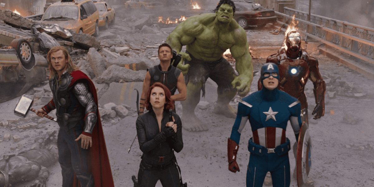 Os Vingadores da Marvel, incluindo Thor, Viúva Negra, Capitão Vingador, Gavião Arqueiro, Homem de Ferro e o Hulk, observam a destruição da cidade.