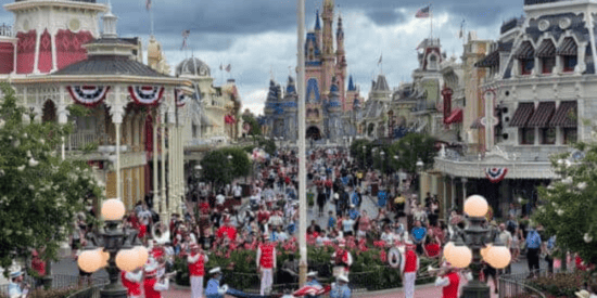 Uma multidão na Main Street, EUA, assistindo à cerimônia da bandeira em frente ao Castelo da Cinderela no Walt Disney World.