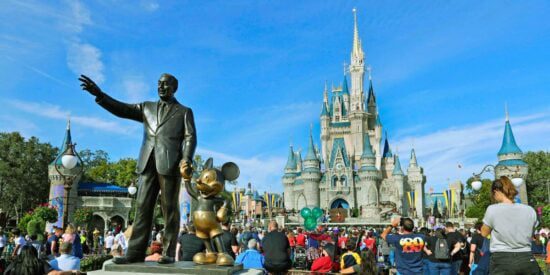 Os visitantes admiram o interior do Magic Kingdom ao lado da estátua de Walt Disney e Mickey Mouse, Partners, no Walt Disney World Resort