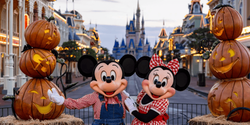 Mickey e Minnie Mouse em frente às decorações de Halloween da Disney no Magic Kingdom Park.