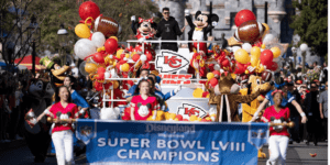 Patrick Mahomes riding on a float celebrating a Super Bowl victory with Mickey Mouse and Minnie Mouse